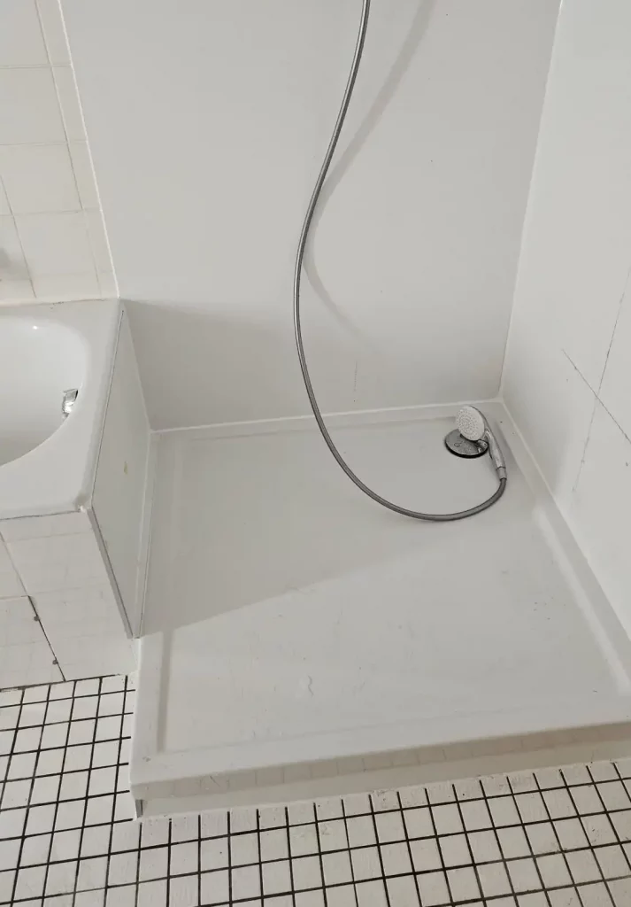 Duschbereich mit weißem Duschboden und flexibler Duschbrause an der Wand. - Praktisches Bad