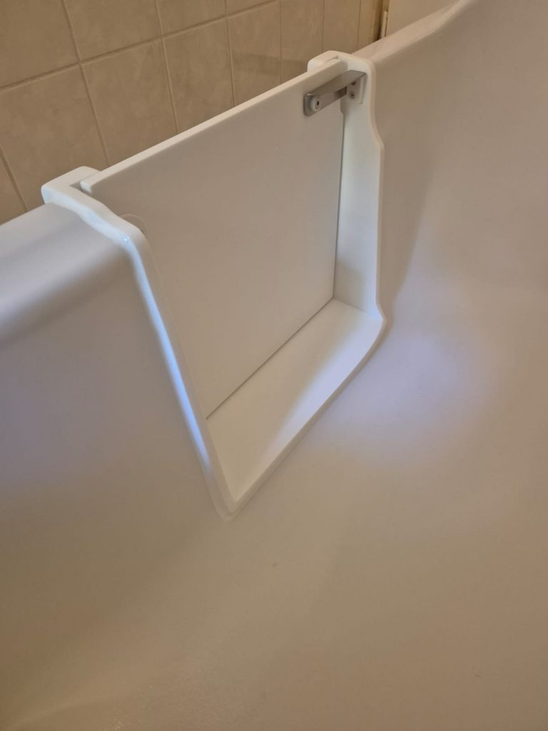 Detailaufnahme einer weißen Badewannenablage mit Halterung an der Wand. - Praktisches Bad