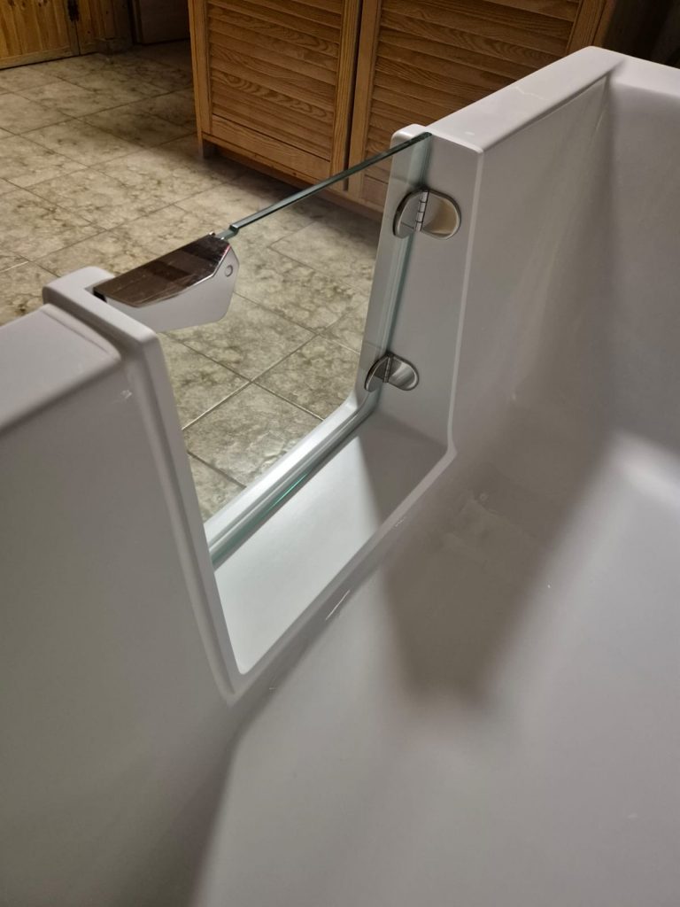 Moderne Badewanne mit Glasabtrennung und eleganten Armaturen in einem stilvollen Badezimmer. - Praktisches Bad