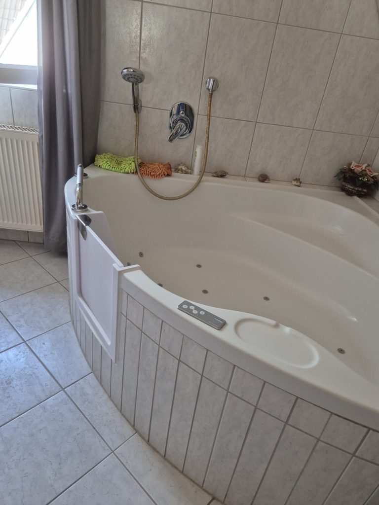 Eine Badewanne mit einer Badewannentür, die den Zugang erleichtert und Sicherheit bietet. - Praktisches Bad