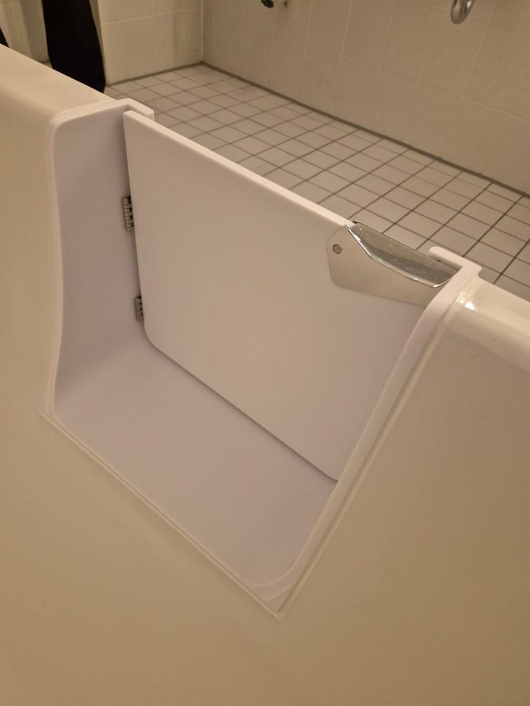Detailansicht einer Badewanne mit einem weißen, klappbaren Zugangselement für einfaches Ein- und Aussteigen. - Praktisches Bad