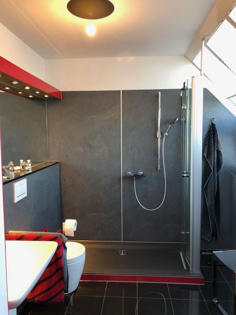 Modernes Badezimmer mit Badewannentür, Dusche und stilvollem Design in neutralen Farben. - Praktisches Bad